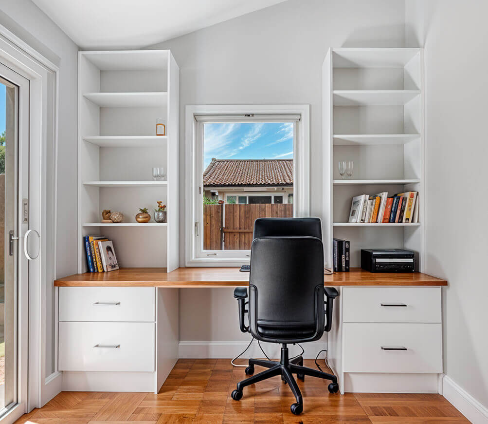 A well-organized home office featuring a desk and a comfortable chair, ideal for productivity and focus.