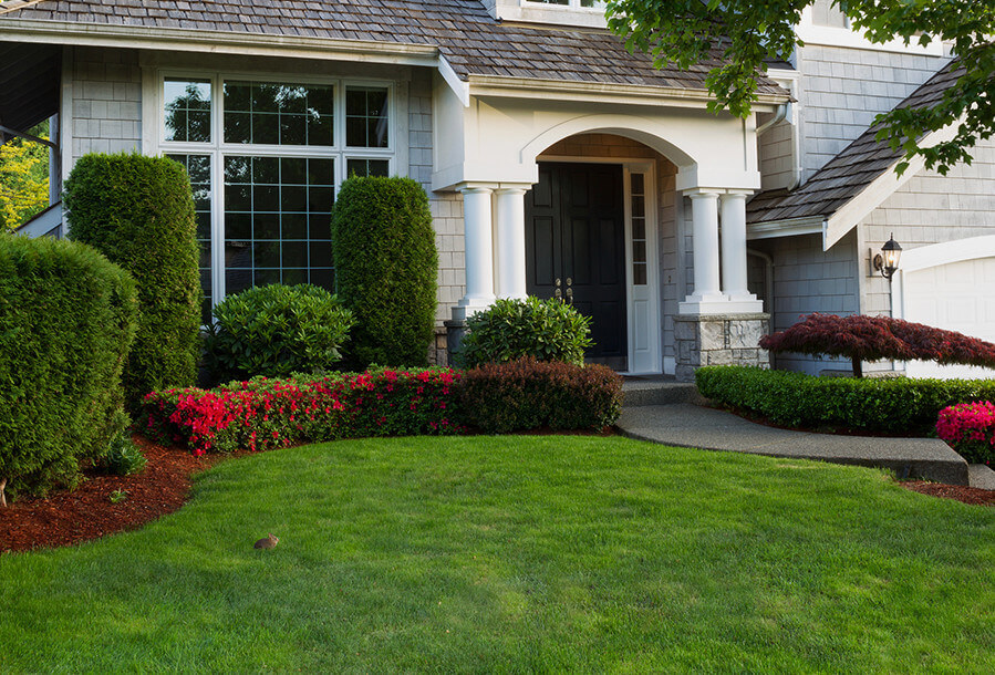A well-manicured lawn, colorful flower beds.