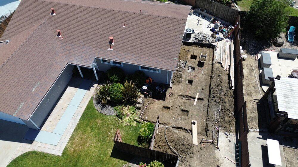 A bird's-eye view of a work in progress. A deep outline carved in the soil framing where the home addition will be situated.